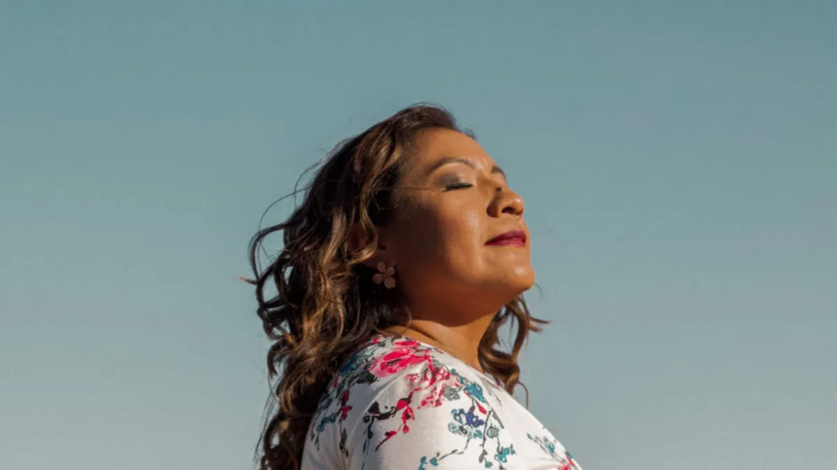 Side profile of a woman enjoying the sun outdoors, exuding calmness and confidence.