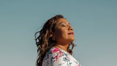 Side profile of a woman enjoying the sun outdoors, exuding calmness and confidence.