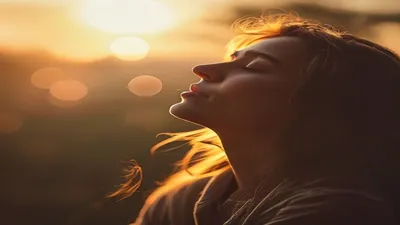 Person breathing deeply at sunrise overlook.