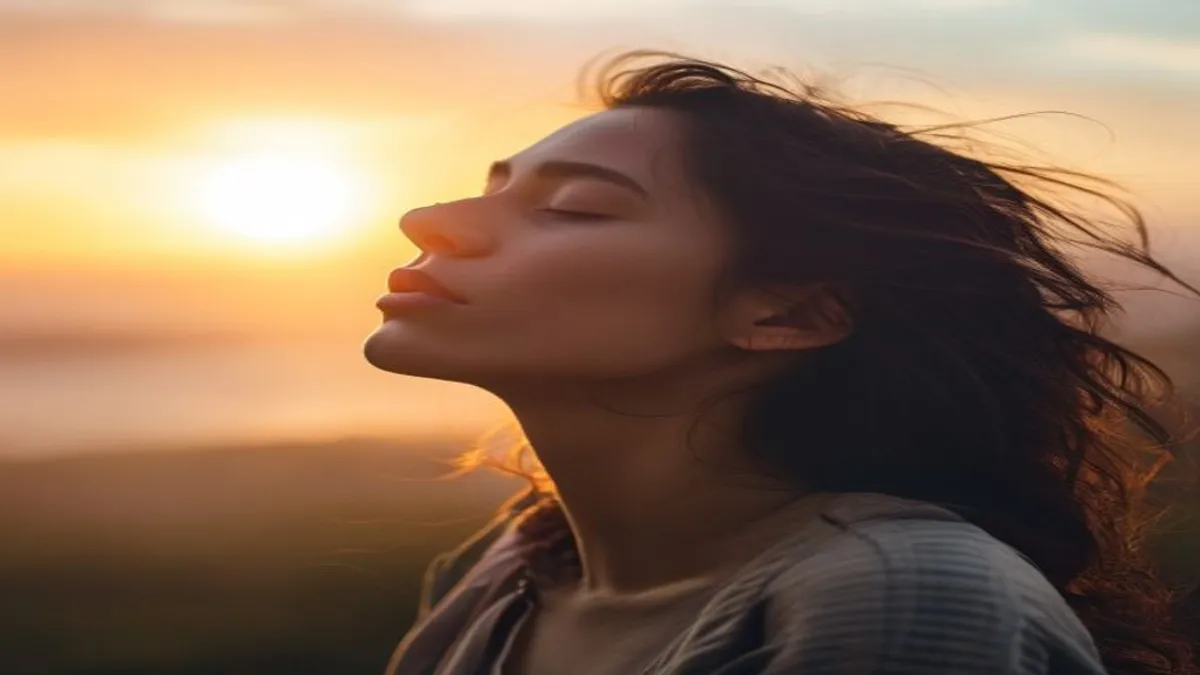 Person breathing deeply at sunrise overlook.