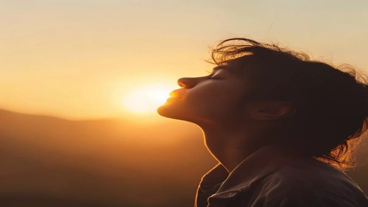 Person breathing deeply at sunrise overlook.