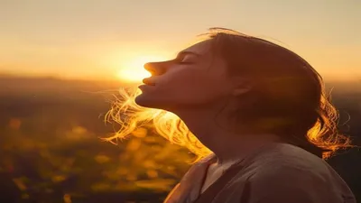 Person breathing deeply at sunrise overlook.