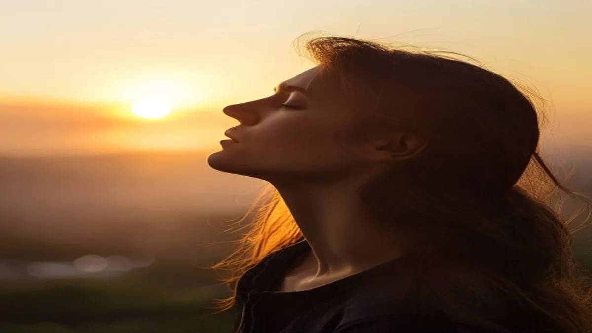Person breathing deeply at sunrise overlook.