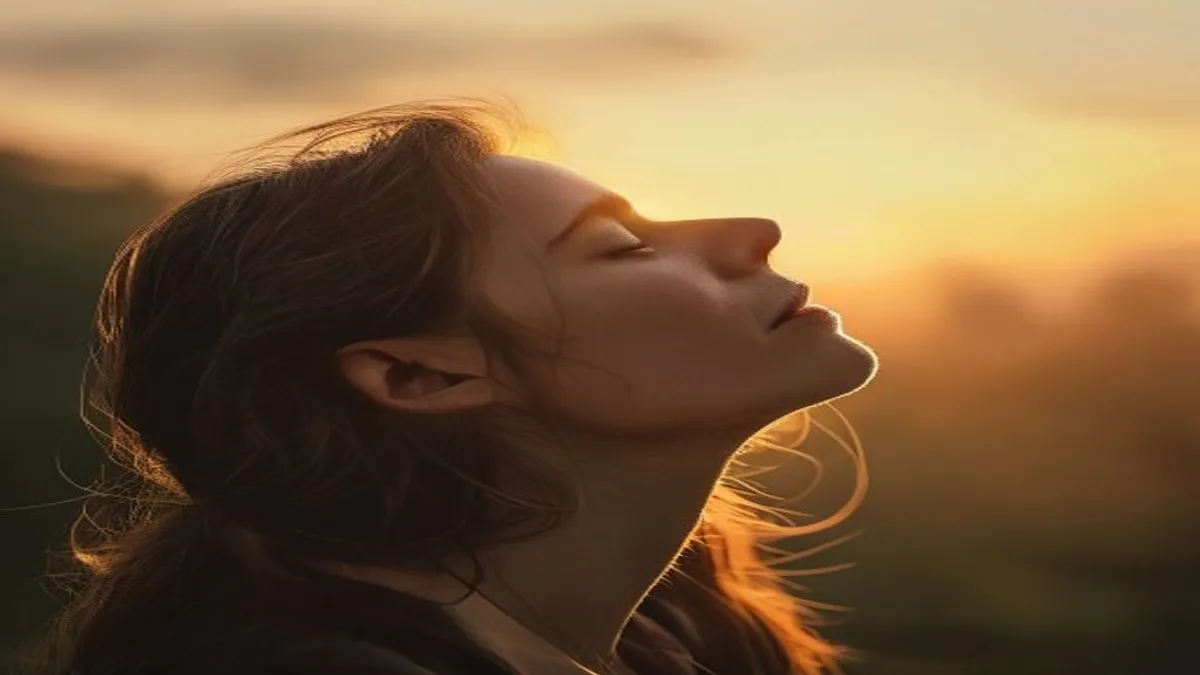 Person breathing deeply at sunrise overlook.