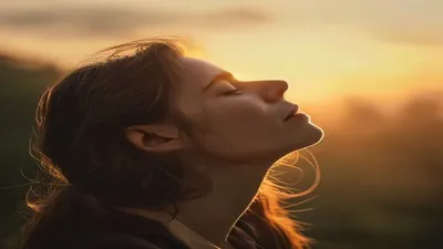 Person breathing deeply at sunrise overlook.