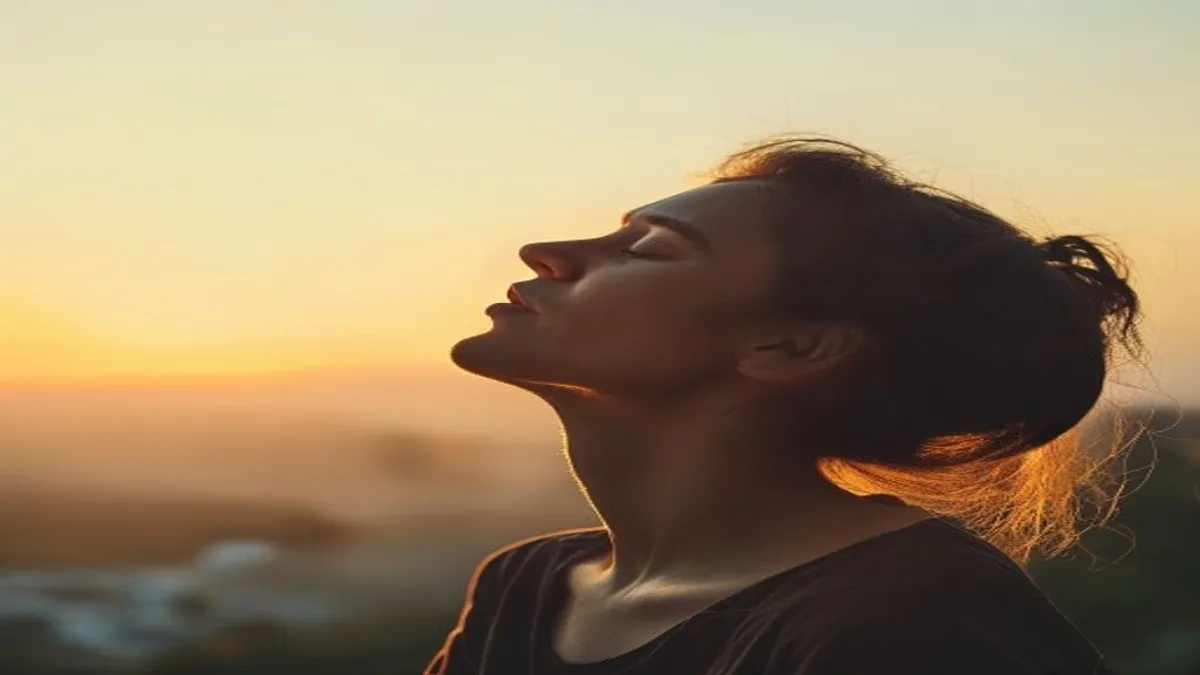 Person breathing deeply at sunrise overlook.