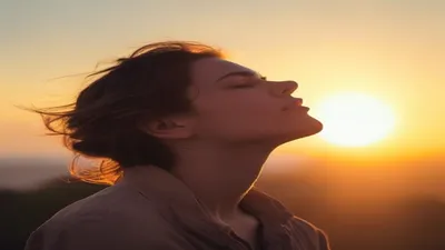Person breathing deeply at sunrise overlook.