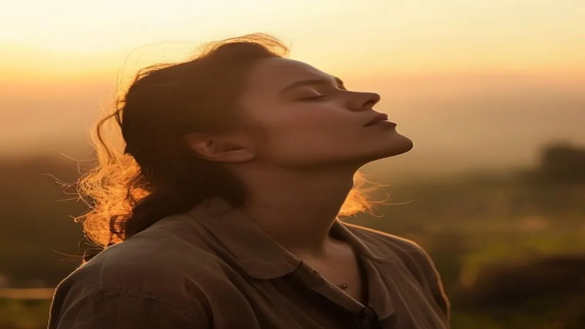 Person breathing deeply at sunrise overlook.