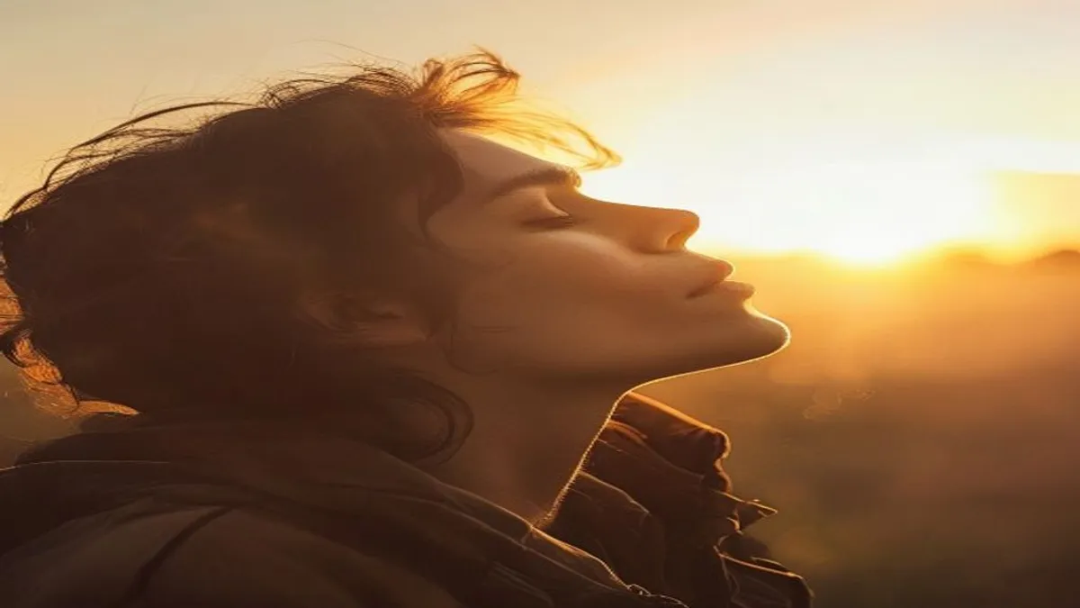 Person breathing deeply at sunrise overlook.