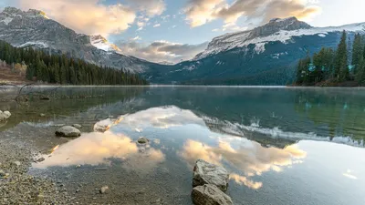 Stunning view of a lake reflecting mountains and clouds in Banff, Alberta, Canada.