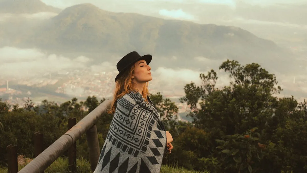 A young woman enjoys a tranquil moment in nature with a scenic mountain backdrop.