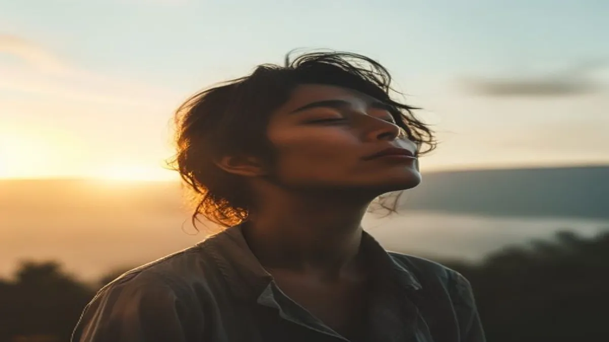 Person breathing deeply at sunrise overlook.
