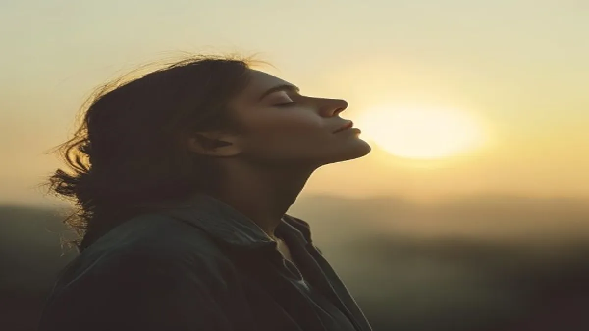 Person breathing deeply at sunrise overlook.