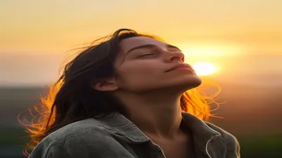 Person breathing deeply at sunrise overlook.