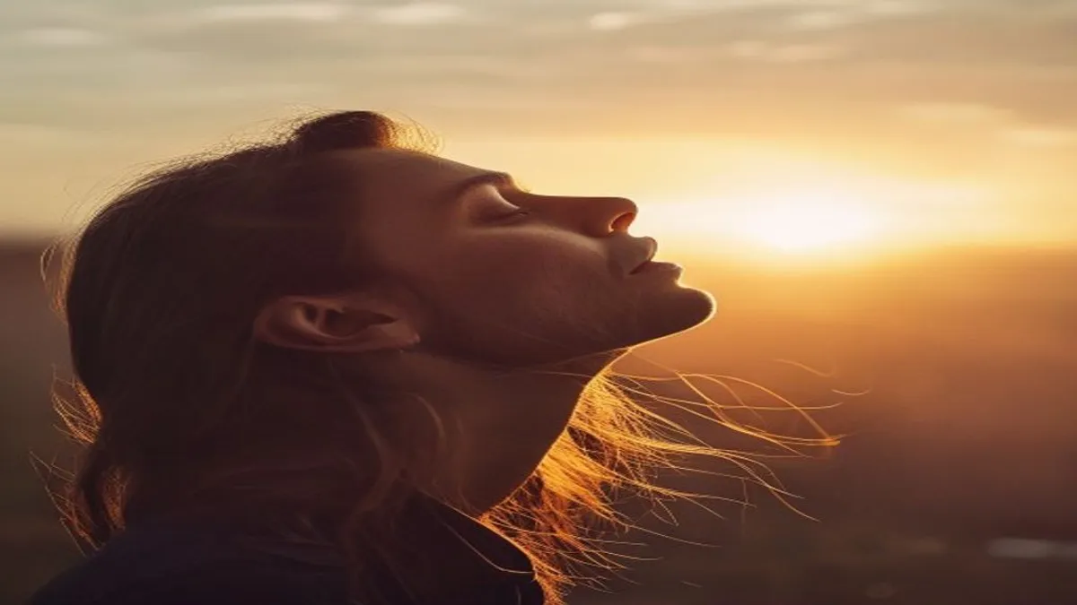 Person breathing deeply at sunrise overlook.