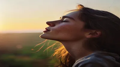 Person breathing deeply at sunrise overlook.