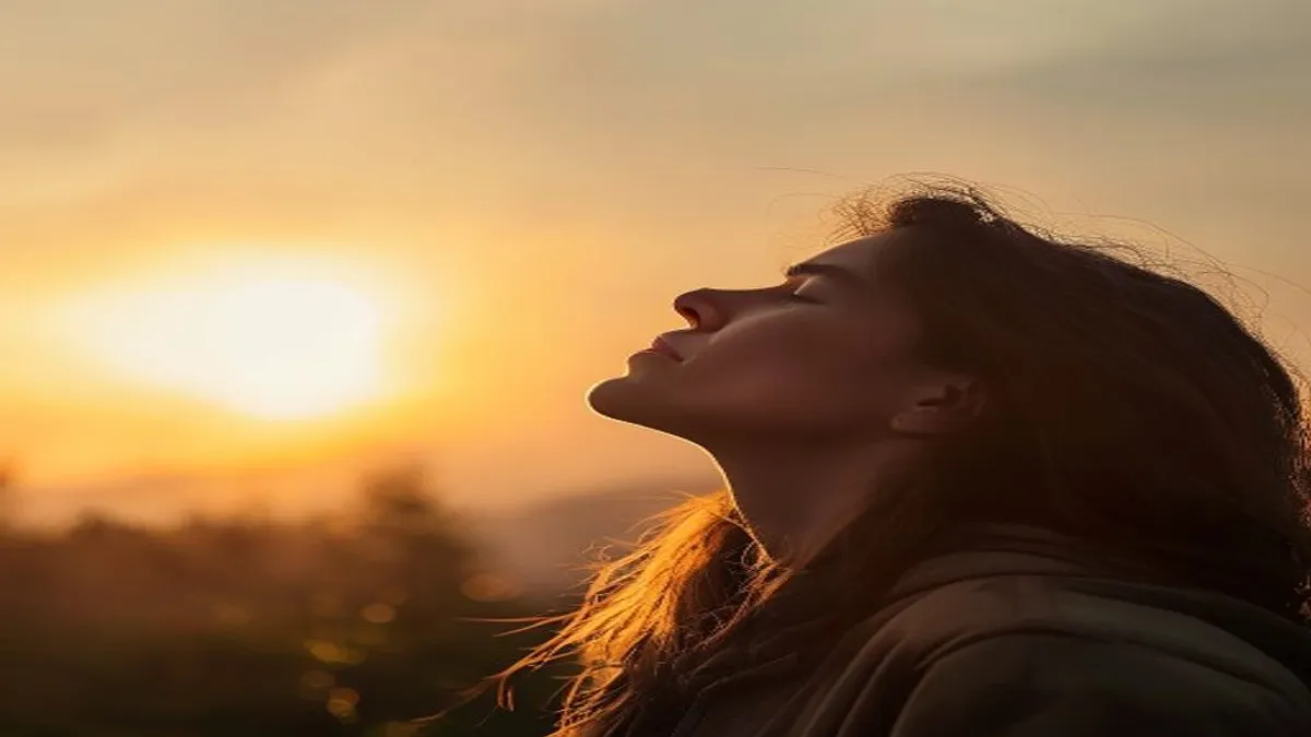 Person breathing deeply at sunrise overlook.