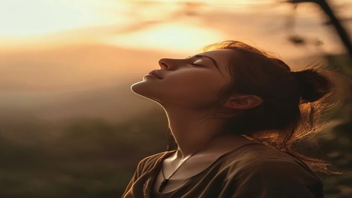 Person breathing deeply at sunrise overlook.