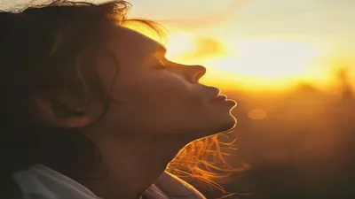 Person breathing deeply at sunrise overlook.